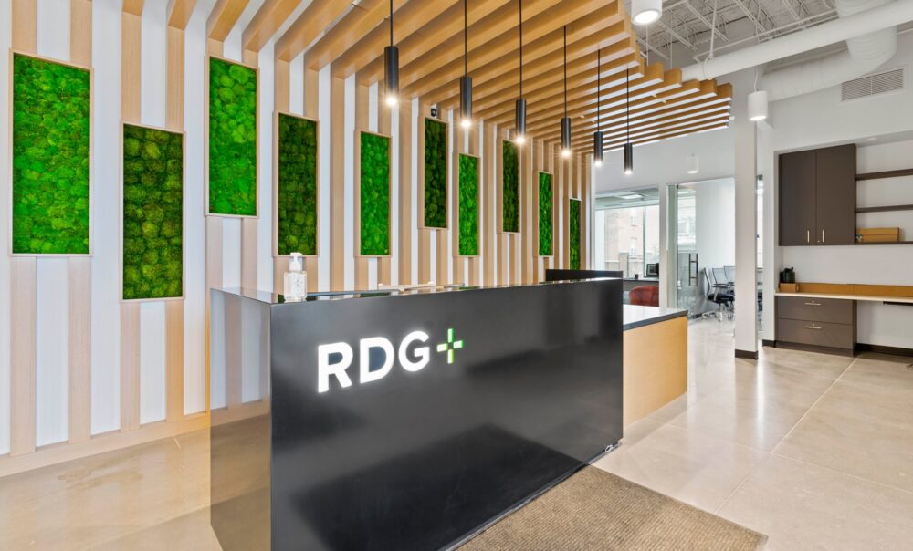 A beautiful contemporary lobby space with greens and metal surfaces at the Rochester headquarters for RDG + Partners