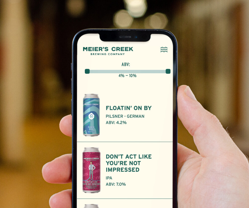 The Beer Archive page showcasing Untappd integration in the website, allowing users the sort beers by style or by ABV, as shown on an iPhone in a person's hand